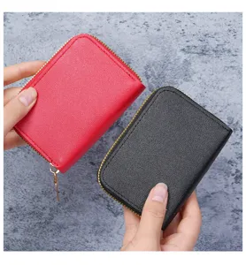 Gros plan de porte-cartes en cuir grainé rouge et noir tenus dans les mains pour l'échelle