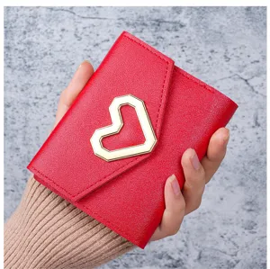 Close-up of red leather coin purse featuring a geometric gold heart clasp detail