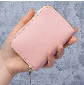 Vue détaillée d'un porte-cartes en accordéon rose minimaliste tenu dans la main