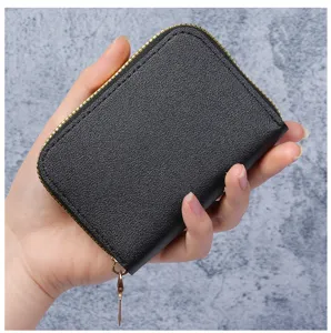 Vue détaillée d'un porte-cartes en cuir noir de style accordéon tenu dans la main