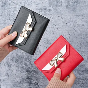 Elegant women's short wallet set featuring golden bow accent and white contrast flap