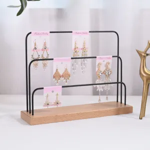 Multi-tier earring display stand detail featuring a sturdy wooden base and black metal frame.
