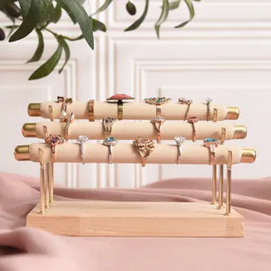 Wooden 3-tier ring display stand with velvet rods and gold metal pillars for jewelry storage.