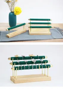 Wooden jewelry display stand detail showing multi-tier green velvet ring holder with gold metal rods.