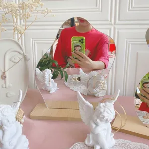Tabletop irregular mirror detail view, featuring cute angel earring holder and jewelry display props.
