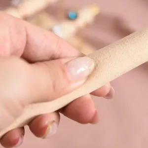 Close-up detail shot of beige velvet ring display stand, soft texture, premium jewelry holder.