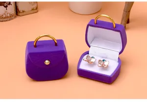 Lila Samt Handtasche Schmuckschatulle mit süßen Schmetterlings-Ohrsteckern für Geschenke.