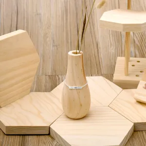 Creative solid wood vase display stand with delicate bracelet prop for jewelry photography.