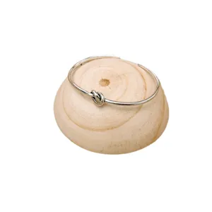 Elegant silver metal knot bangle bracelet, minimalist open cuff design for daily wear.