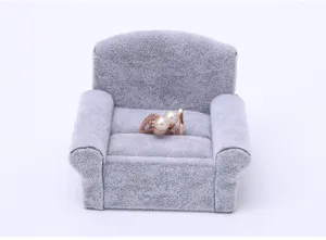 Detailed view of grey velvet sofa ring holder, elegant jewelry display prop for earrings and rings.