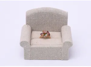 Close-up detail of miniature linen sofa ring holder displaying jewelry, perfect for ring storage.