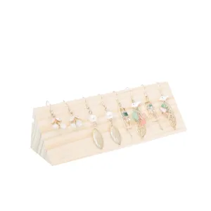 Wooden jewelry display stand detail showing natural wood texture and earring arrangement.