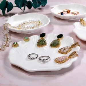 Exquisite jewelry display set featuring pearl necklaces, crystal rings and chic earrings on shell trays.