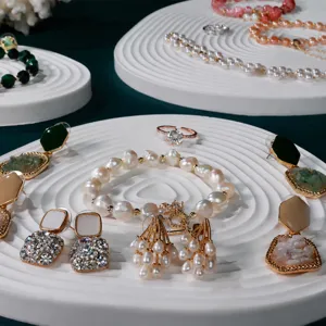 Detailed view of exquisite pearl bracelets, earrings, and rings displayed on a white tray.