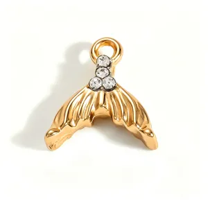 Macro view of a golden mermaid tail pendant with sparkling rhinestones and 18K gold plating