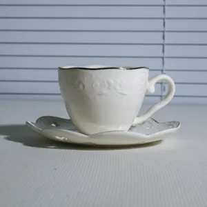 Witte keramische koffiekop en schotel set met goud rand en reliëf detail, klein 180ml.