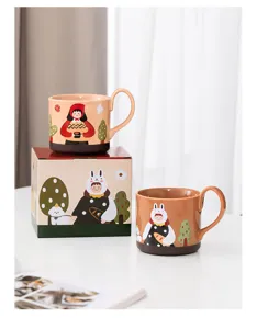 Ceramic mug detail showing cute cartoon illustration design, coffee cup with handle and gift box.