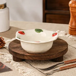 Keramische aardbei dessert kom detail, handgeschilderd fruit patroon op wit servies artikel.