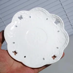 Platillo de café de cerámica blanca con encaje en relieve y diseño hueco, plato de té elegante.