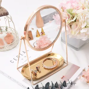 Gold desktop makeup mirror with rotating oval glass and storage tray for daily vanity use.