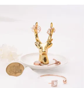 Gold ceramic deer head jewelry dish detail view, elegant ring and earring storage tray.