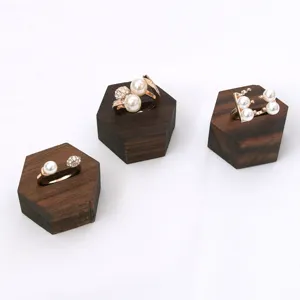 Solid wood hexagonal jewelry display stand set with elegant pearl rings on white background