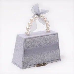 Grijs fluwelen handtas sieraden organizer met parel handvat voor ringen en oorbellen display standaard.