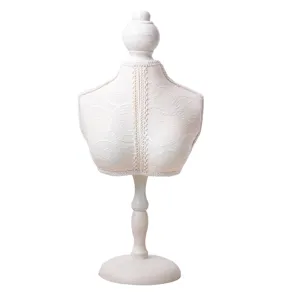 Vintage witte kant paspop sieraden display standoor oorbellen ringen kettingen tafel.