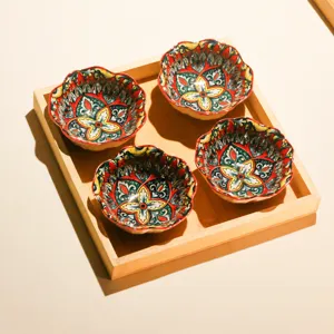 Detailansicht von 4 keramischen Blumenschalen im Holztischset im bunten Bohostil Design.