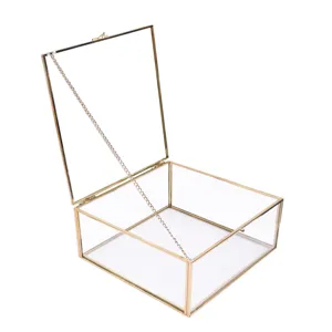 Minimalist square glass jewelry display box with gold metal frame and open lid chain.