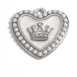 Macro detail of a silver heart pendant featuring a central crown and pearl border.