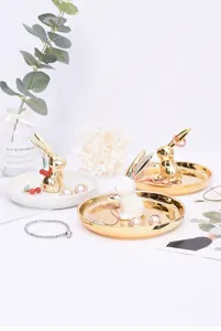 Gedetailleerd overzicht van keramische konijn sieraden opbergtrays, gouden en witte stijl.