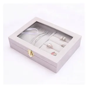 Graue Samt Schmuckschatulle mit Glasdeckel, Ringfächern und Aufbewahrungsbox für Accessoires.