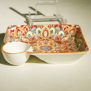Detailaufnahme des Keramik-Dumpling-Tellers mit Sauciere und bunten traditionellen Mandala-Mustern.