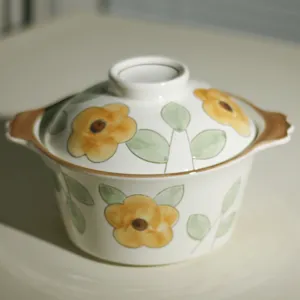 Gedetailleerd overzicht van keramische soepkom met deksel, bloemenpatroon en dubbele handgrepen.
