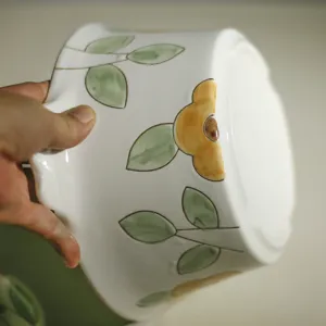 Detailopname van een handgeschilderde keramische soepkom met subtiel bloemmotief en glanzend glazuur.