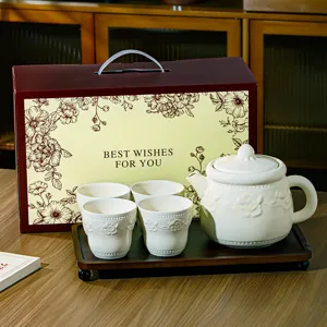 Détail du service à thé en céramique avec théière tasses et plateau en bois élégant.