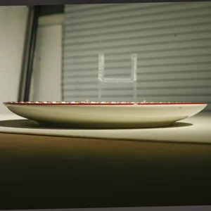 Ceramic dinner plate detail view, side profile showing shallow depth and bohemian rim design.