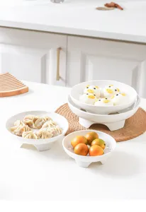 Detailed view of white ceramic elevated steaming plates showing multi-purpose kitchen food display.
