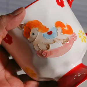 Keramiktasse Detailansicht mit handgemaltem 3D-Schaukelpferd und bunten Blumenmotiven.