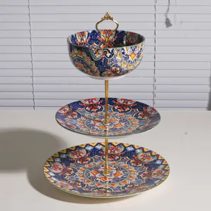 Vista detallada del soporte para postres de cerámica de tres niveles con motivos bohemios.