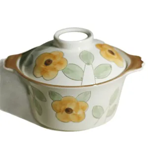Keramische soepkom met deksel, dubbele oren en handgeschilderd geel bloemmotief voor keuken.