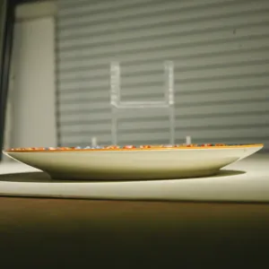 Detailed side view of ceramic dinner plate showing rim thickness and colorful bohemian pattern profile.