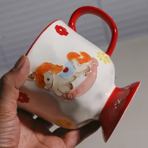 Keramiktasse Detail mit 3D-Relief-Pony-Muster, rotem Henkel und elegantem hohem Fuß.