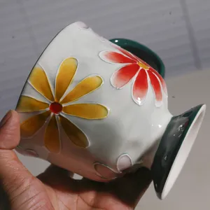 Detailaufnahme der handbemalten Keramiktasse mit Blumenmuster für perfekten Kaffeegenuss morgens.
