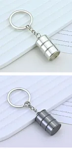Detail view of two metal oil drum keychains in silver and gunmetal finish