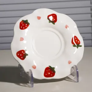 Precioso platillo de café de cerámica con motivo de fresa, diseño de borde ondulado.