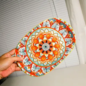 Detailed view of bohemian style ceramic oval plate with intricate mandala pattern and vibrant colors.