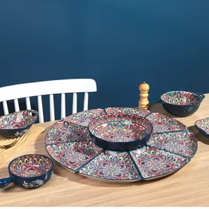 Close-up detail of bohemian ceramic tableware set with colorful ethnic patterns on table.