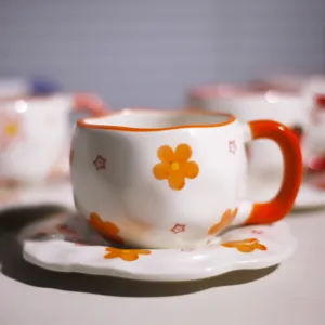 Detalle de taza y plato de café de cerámica pintada a mano, lindo patrón floral y diseño creativo.